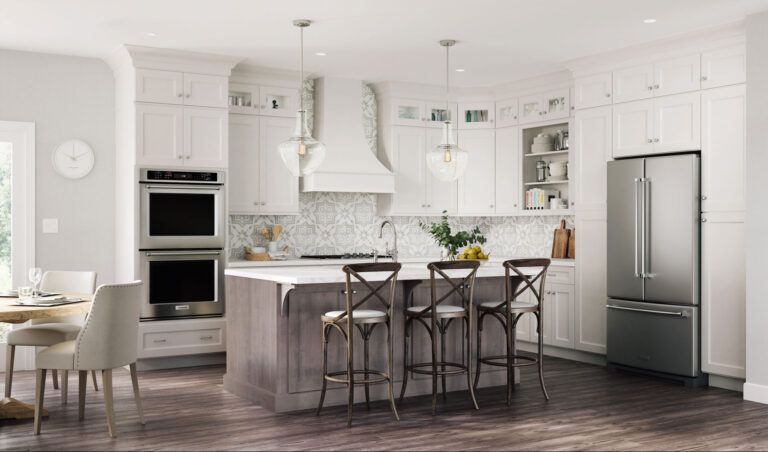A bright, modern kitchen with white cabinets, stainless steel appliances, and a gray island with bar stools.